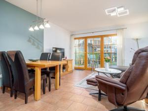 Una sala de estar con mesa de comedor y sillas. en Ferienpark Freesenbruch Wohnung 2 1 - Möwennest, en Zingst