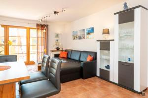 un soggiorno con un divano nero e un tavolo di Ferienpark Freesenbruch Wohnung 3 1 - Schöne Auszeit a Zingst