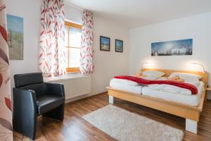 una camera da letto con un letto e una sedia di Ferienpark Freesenbruch Wohnung 3 1 - Schöne Auszeit a Zingst Altre 29 foto