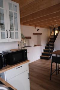 a kitchen with a microwave on a counter with a staircase at Les campanules in Lanvénec