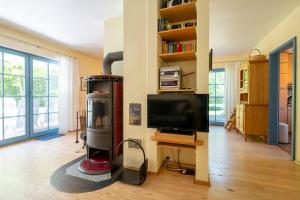 Ferienpark Freesenbruch Doppelhaushälfte 12a - Steuerrad في زنغست: غرفة معيشة مع تلفزيون بشاشة مسطحة ومحطة تلفزيون