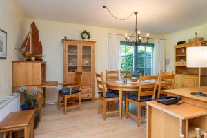 Ferienpark Freesenbruch Doppelhaushälfte 12a - Steuerrad في زنغست: مطبخ وغرفة طعام مع طاولة وكراسي