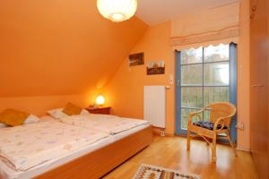 Ferienpark Freesenbruch Doppelhaushälfte 12a - Steuerrad في زنغست: غرفة نوم بها سرير وكرسي ونافذة +30 صورة