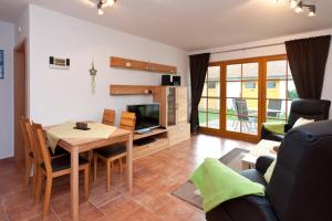 un soggiorno con un tavolo e una televisione di Ferienpark Freesenbruch Wohnung 4 2 - Ostseeperle a Zingst