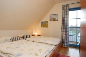 ein Schlafzimmer mit einem Bett und einem Fenster in der Unterkunft Ferienpark Freesenbruch Doppelhaushälfte 12 - Sommerlust in Zingst + 32 Fotos