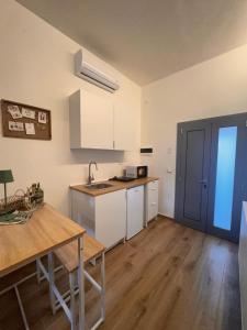 eine Küche mit weißen Schränken und einem Holztisch in der Unterkunft Villatico 25 in Chiari