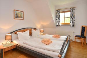 a bedroom with a bed with orange towels on it at Ferienpark Freesenbruch Wohnung 3 5 - Muschelsucher in Zingst +29 photos