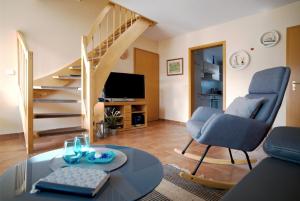 un soggiorno con scala, sedia e tavolo di Ferienpark Freesenbruch Wohnung 3 6 - Frieda a Zingst
