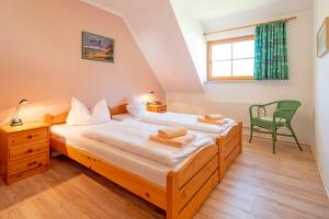 una camera con due letti e una sedia verde di Ferienpark Freesenbruch Wohnung 1 5 - Amber a Zingst Altre 30 foto