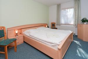 Un dormitorio con una cama grande y una silla en Ferienpark Freesenbruch Wohnung 2 2 - Bernstein, en Zingst 23 fotos más