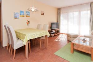 Una sala de estar con una mesa y sillas y un televisor. en Ferienpark Freesenbruch Wohnung 2 2 - Bernstein, en Zingst