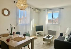 a living room with a table and a couch at Agréable villa avec piscine à 100 m de la plage - 10B14J35 in Le Barcarès