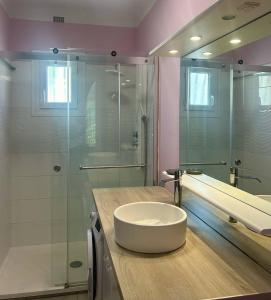 a bathroom with a sink and a glass shower at Agréable villa avec piscine à 100 m de la plage - 10B14J35 in Le Barcarès