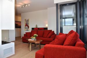 een woonkamer met rode banken en een tafel bij Logierhaus Friedrich WE 24 - "Sandläufer" in Zingst