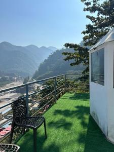 a chair on a balcony with a view of a mountain at LA Foresta resort by Utopia in Shivpuri +10 photos