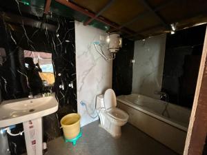 a bathroom with a sink and a toilet and a tub at LA Foresta resort by Utopia in Shivpuri