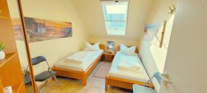 青斯特Residenz am Strand Wohnung 2-39的有两张床和一扇窗户的小房间