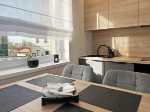 una cucina con tavolo, sedie e finestra di Poznań Wilda -Apartament Fabryczna a Poznań