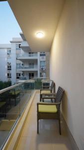 two chairs sitting on a balcony with a building at Mountain View i city October in 6th Of October