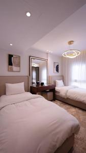 a hotel room with two beds and a mirror at Mountain View i city October in 6th Of October