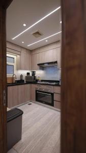 a large kitchen with wooden cabinets and an oven at Mountain View i city October in 6th Of October