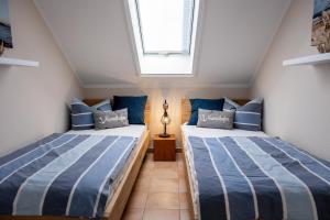 青斯特Residenz am Strand Wohnung 6-80的带窗户的房间里有两张单人床