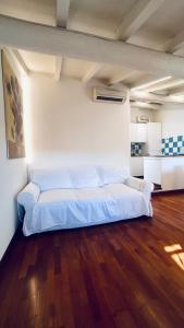 ein großes weißes Bett in einem Zimmer mit Holzboden in der Unterkunft Casa MiA in Salò + 3 Fotos