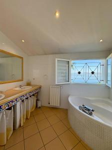 a large bathroom with a tub and two sinks and a window at Villa piscine privée superbe Vue Etang Leucate 8JBART580 in Port Leucate