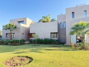 a house with a lawn in front of it at Villa Five Collection - Private Luxury & Heated Pool in Ouled Moumene