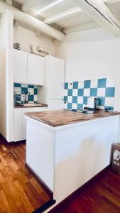 eine Küche mit weißen Schränken und blauen und weißen Fliesen in der Unterkunft Casa MiA in Salò