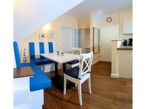 a dining room and kitchen with a table and chairs at Neue Reihe 28 - Wohnung Vogelnest in Zingst +12 photos