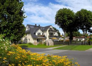 a white house with a black roof at Neue Reihe 28 - Wohnung Vogelnest in Zingst