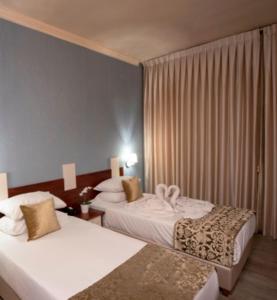 a hotel room with two beds in a room at Aristocrat Hotel Haredi in Bnei Brak