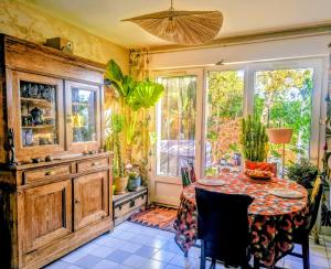 a dining room with a table and a window at La Villa Bleue in Beauchastel