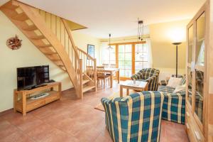 un soggiorno con un divano e una TV di Ferienpark Freesenbruch Wohnung 4 4 - Seeschwalbe a Zingst