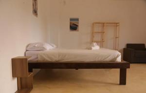 Bett in einem Zimmer mit Stuhl in der Unterkunft Casa andrea in Guriú