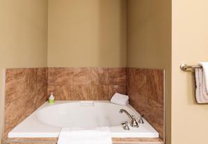 a bath tub in a bathroom with brown tiles at El Paraiso - Luxury Downtown Penthouse in Canmore +30 photos