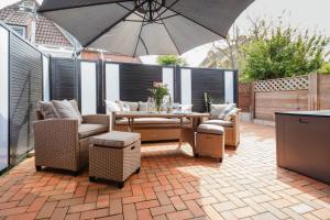 Un patio con una mesa y sillas y una sombrilla. en SeaSide, en Norderney