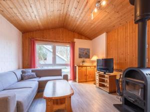 a living room with a couch and a stove at Ferienhaus im Ferienpark Mirow in Granzow