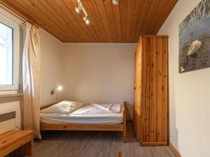 a bed in a room with a wooden ceiling at Ferienhaus im Ferienpark Mirow in Granzow