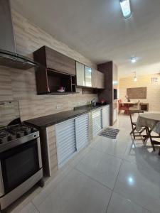 a kitchen with a stove and a dining room with a table at Casa Praia Bertioga in Bertioga