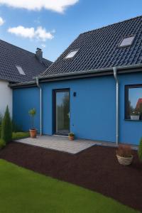 una casa blu con un patio in un cortile di Dat-Fischerhuus-Kapitaenskoje-zwischen-Ostsee-und-Bodden-direkt-am-Hafen a Pruchten