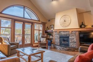 a living room with a fireplace and a tv at Cascade Penthouse by Canadian Rockies Vacation Rentals in Canmore