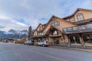 a building with cars parked on the side of a street at Cascade Penthouse by Canadian Rockies Vacation Rentals in Canmore