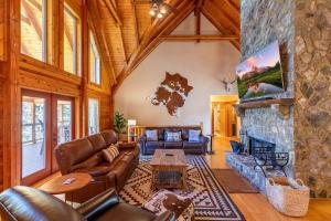 a living room with leather furniture and a stone fireplace at Whiskey River by The New in Jefferson
