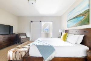 una camera da letto con un letto grande e una televisione di Rocky Mountain High at Grande Rockies Resort a Canmore Altre 40 foto
