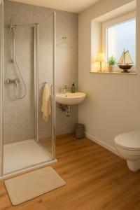 un bagno con doccia, WC e lavandino di Dat-Fischerhuus-Ankerplatz-zwischen-Bodden-und-Ostsee-in-30-sek-am-Hafen a Pruchten