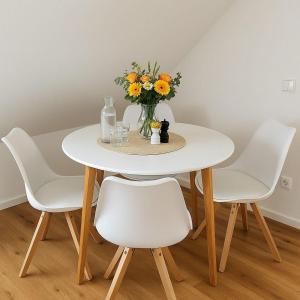 un tavolo bianco con sedie e un vaso di fiori di Dat-Fischerhuus-die-Seemannskoje-zwischen-Bodden-und-Ostsee-direkt-am-Hafen a Pruchten Altre 3 foto