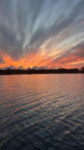 un tramonto su un grande specchio d'acqua di Dat-Fischerhuus-Ankerplatz-zwischen-Bodden-und-Ostsee-in-30-sek-am-Hafen a Pruchten