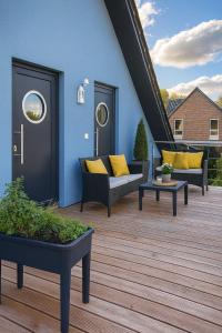 una terrazza con divani e sedie su una casa di Dat-Fischerhuus-die-Lotsenstube-zwischen-Ostsee-und-Bodden-30sek-zum-Hafen a Pruchten